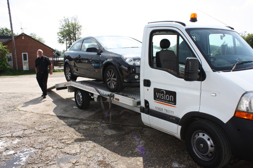 car being towed on the back of a van